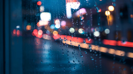 Obraz premium Rainy night city bus window view, blurred lights