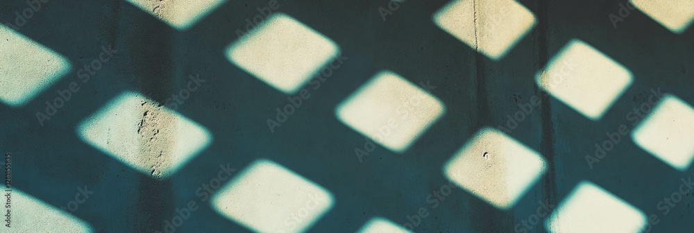 Poster pattern of fine metal grid shadows on rough concrete surface for architecture design and texture bac
