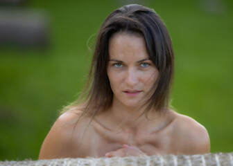 A beautiful woman in a lush green field with calm eyes