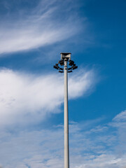 Public street light pole with LED lights and stunning cloudy blue sky background. Street lights function for street lighting and public safety.
