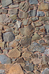 Rustic stone wall texture showcases a blend of colors and shapes in a charming ancient setting
