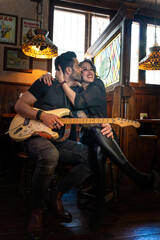 Obraz premium Musicians couple kissing and embracing in irish pub