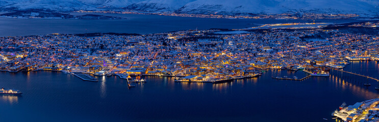 panoramic aerial view of Tromsø at blue hour with beautiful yellow lights, surrounded by dark blue sea Utsiktspunkt, Norway