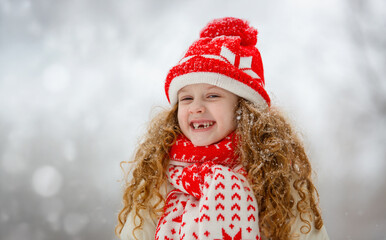 Portrait of smiling toothless girl in winter park. Happy childhood concept.