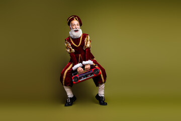 Elderly man in medieval attire with a modern stereo, blending historical fashion and modern...