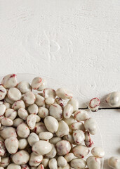 Lots of delicious candies on a transparent plate. Dried fruits in chocolate on a white wooden background.