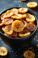 Baked banana chips, dark bowl, sesame seeds