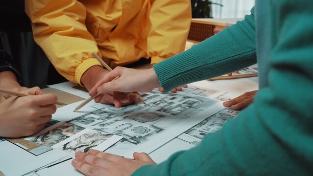 A vibrant scene of diverse individuals collaborating on storyboarding comic artwork. They are enthusiastically sketching and sharing ideas in a creative workspace. SACTR