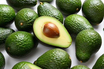 there is a large avocado cut in half and surrounded by smaller avocados