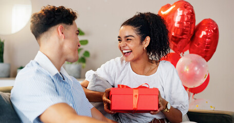 Love, gift and smile with couple on sofa for valentines day celebration, box or bonding....