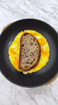 Breakfast fried and scrambled eggs, with sourdough bread.