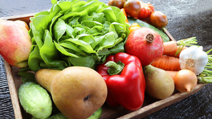 Organic vegetables from the  garden - carrots, tomatoes, peppers, cucumbers, lettuce  and  fruits in wooden box . Raw healthy food concept. Top view