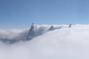 View of the French Alps with a blue sky and clouds covering the peaks above 3000 m above sea level