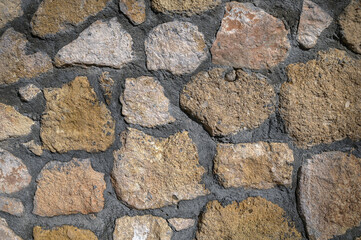 Obraz premium Intricately arranged natural stones create a rustic wall texture in an outdoor setting