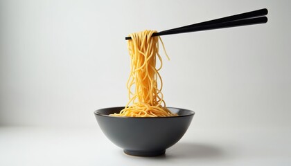 Ramen noodles in black bowl on white background held with chopsticks. Asian wheat pasta dish with broth. Traditional japanese soup food with oriental yellow noodles.
