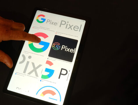Hand holding tablet, on GOOGLE icon on black background, February 21, 2025
