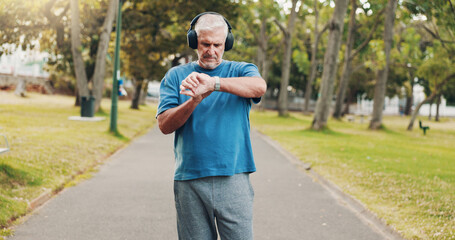 Outdoor, senior man and smart watch for fitness, exercise steps and training performance. Park, wristwatch and sports athlete with workout results, timer and body health with headphones for music