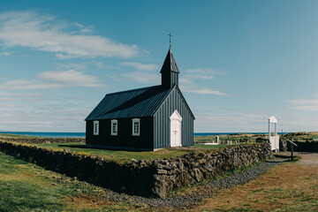 Búðakirkja, the iconic black wooden church in Búðir, Snæfellsnes Peninsula, West Iceland, surrounded by rugged coastal scenery.