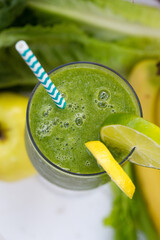 Refreshing green smoothie with lemon and lime garnish in a glass