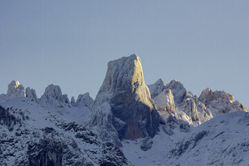 Beautiful snowy high mountain landscape with the Naranjo de Bulnes or Picu Urrielu among the mists...