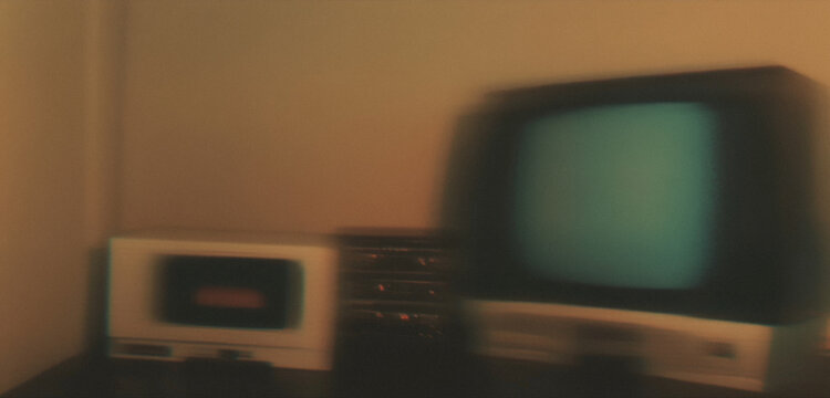 Blurry retro technology: vintage television and early computer setup