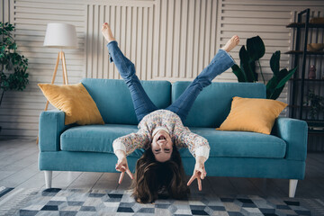 Obraz premium Joyful young woman in casual wear enjoying on sofa in bright cozy living room
