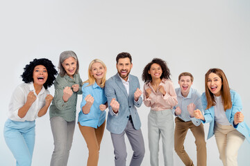 Cheerful diverse group of colleagues celebrating together with enthusiasm on a grey background