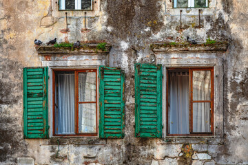Windows in wall of ancient stone house in old town.