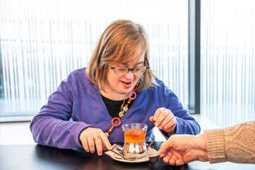 41 yo woman with the Down syndrome learning to brew tea, Tienen, Belgium