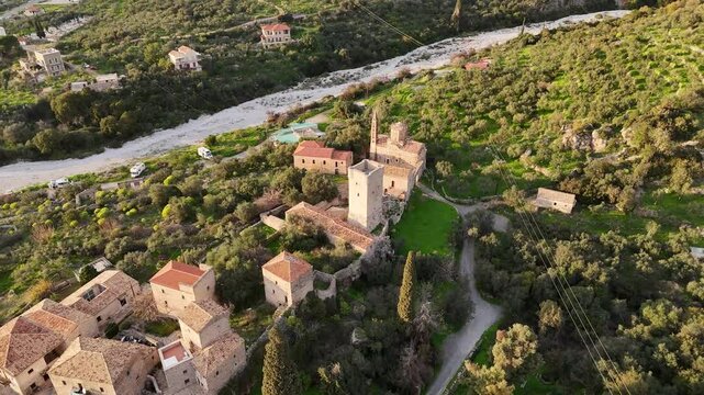 Aerial view of Mourtzinos Tower and Church of St. Spyridon during sunset in the town of Kardamyli on the Mani Peninsula, Greece.