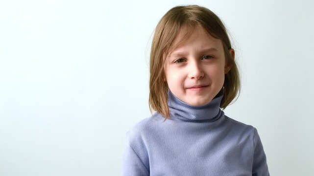 Young girl in light blue turtleneck coughing into bent elbow on plain background, highlighting personal hygiene practice