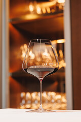 A glass of red wine on the background of a wine refrigerator.