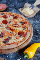 Hot tasty traditional various italian pizzas with salami, meat, cheese, onion, mushroom, tomatoes greens on a dark background