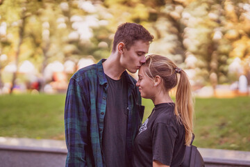 Obraz premium A beautiful young couple kissing outdoors. Relationships between a man and a woman, romance