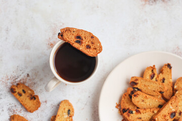 Italian raisin almond biscotti and glass of milk on light background.