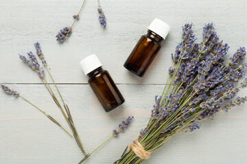 Bottles with lavender extract on wooden background,, top view