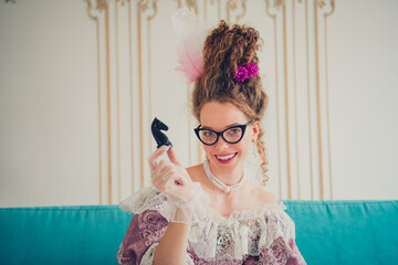 Elegant young woman wearing vintage costume with playful gaze and a modern touch