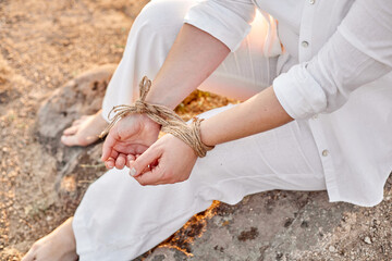 Woman's hands tied with rope
