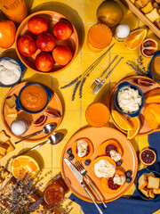 Vibrant brunch spread featuring fresh fruit, yogurt, and citrus delights on a sunny yellow table