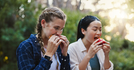 Eating, food and hiking with friends in nature for lunch break, trekking adventure and park conservation. Hungry, conversation and environment with women in forest for snack, relax and peace together