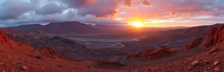 Panoramic view of Timanfaya National Park volcanic landscape in Lanzarote, Canary Islands at sunset. Sun rays pierce through clouds. Reddish ground contrasts with dark mountains. Tourist attraction
