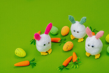 Handmade Easter concept. Knitted bunnies with traditional decoration. Festive symbols, greeting card