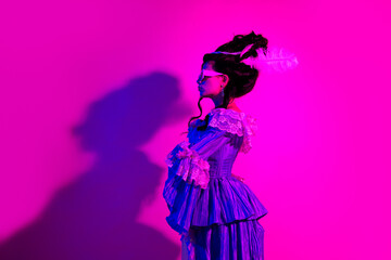 A fashionable young woman in a Baroque-inspired outfit in vibrant pink lighting, exuding elegance and artistic allure.