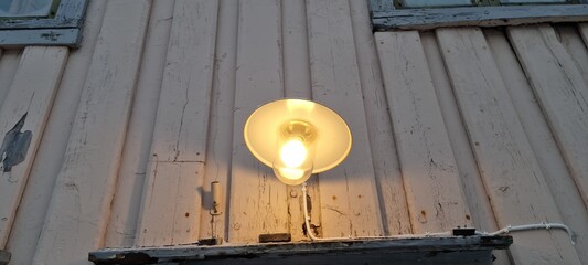 old fashioned porch ligh on weathered building wall