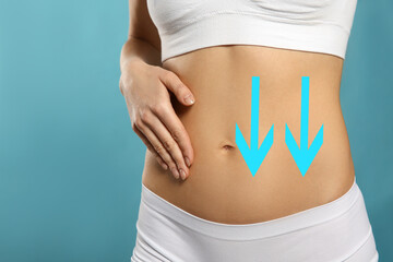 Woman with healthy digestion on light blue background, closeup. Arrows symbolizing proper functioning of digestive tract