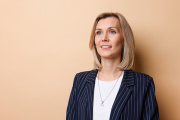 Obraz premium Portrait of happy businesswoman on beige background, space for text