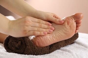Woman receiving foot massage in spa salon, closeup