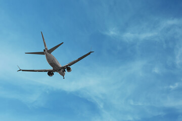Airplane flying in beautiful blue sky with clouds