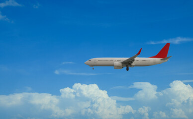 Airplane flying in beautiful blue sky with clouds