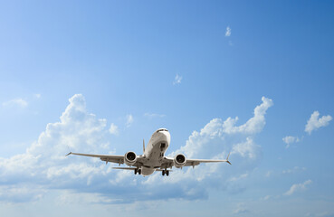Airplane flying in beautiful blue sky with clouds